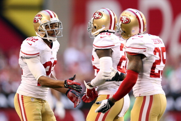 GLENDALE, AZ - DECEMBER 29:   Carlos Rogers #22 of the San Francisco 49ers celebrates with teammates Tramaine Brock #26 and  Tarell Brown #25 after a turnover on downs in the third quarter against the Arizona Cardinals during a game at University of Phoen