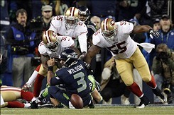 Jan 19, 2014; Seattle, WA, USA; San Francisco 49ers players Ahmad Brooks (55) and Donte Whitner (31) chase after a fumble with Seattle Seahawks quarterback Russell Wilson (3) during the second half of the 2013 NFC Championship football game at CenturyLink
