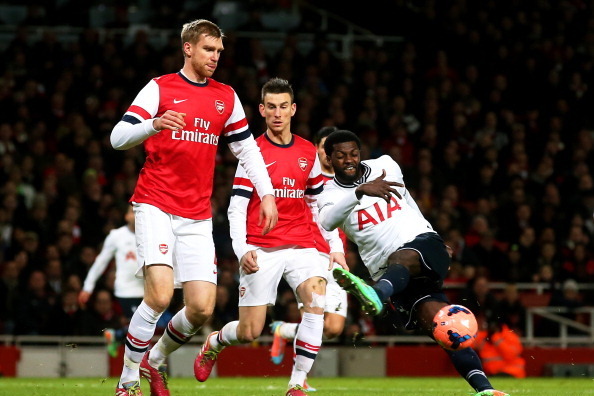 LONDON, ENGLAND - JANUARY 04:  Emmanuel Adebayor of Spurs miscues a shot on goal as Per Mertesacker (L) and Laurent Koscielny (C) of Arsenal close in and during the Budweiser FA Cup third round match between Arsenal and Tottenham Hotspur at Emirates Stadi