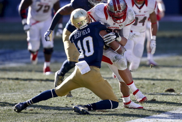 NEW YORK, NY - DECEMBER 28:  Max Redfield #10 of the Notre Dame Fighting Irish tackles Tyler Kroft #86 of the Rutgers Scarlet Knights during the New Era Pinstripe Bowl at Yankee Stadium on December 28, 2013 in the Bronx borough of New York City.  (Photo b