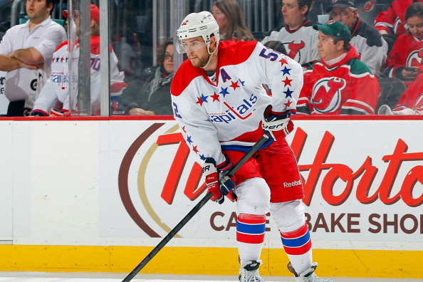 NEWARK, NJ - JANUARY 24: Mike Green #52 of the Washington Capitals plays the puck against the New Jersey Devils during the game at the Prudential Center on January 24, 2014 in Newark, New Jersey.  (Photo by Andy Marlin/NHLI via Getty Images)
