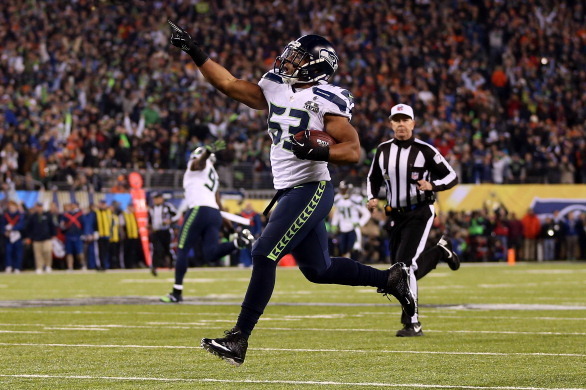 EAST RUTHERFORD, NJ - FEBRUARY 02:  Outside linebacker Malcolm Smith #53 of the Seattle Seahawks runs 69-yards for a touchdown after intercepting a pass intended for running back Knowshon Moreno #27 of the Denver Broncos in the second quarter during Super