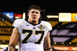 Dec 28, 2013; Tempe, AZ, USA; Michigan Wolverines offensive lineman Taylor Lewan (77) walks off the field following the game against the Kansas State Wildcats during the Buffalo Wild Wings Bowl at Sun Devil Stadium. Kansas State defeated Michigan 31-14. M