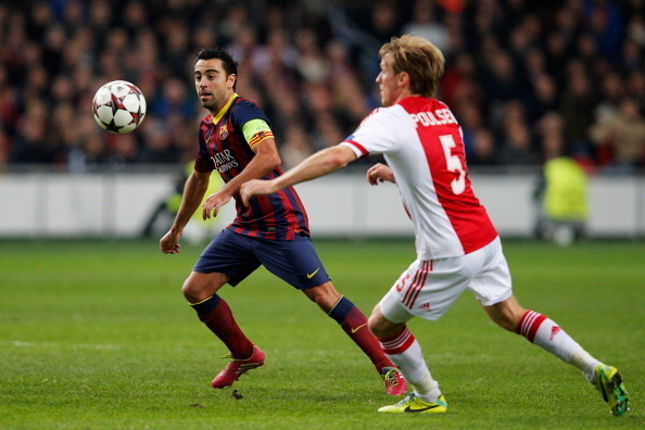 AMSTERDAM, NETHERLANDS - NOVEMBER 26:  Christian Poulsen of Ajax and Xavi of Barcelona battle for the ball during the UEFA Champions League Group H match between Ajax Amsterdam and FC Barcelona at Amsterdam Arena on November 26, 2013 in Amsterdam, Netherl