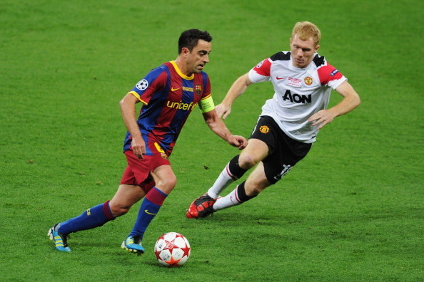 LONDON, ENGLAND - MAY 28:  Xavi of FC Barcelona is watched by Paul Scholes of Manchester United during the UEFA Champions League final between FC Barcelona and Manchester United FC at Wembley Stadium on May 28, 2011 in London, England.  (Photo by Michael 