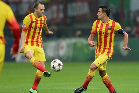 MILAN, ITALY - OCTOBER 22:  Xavi Hernandez and Andres Iniesta of FC Barcelona (L) during the UEFA Champions League Group H match between AC Milan and Barcelona at Stadio Giuseppe Meazza on October 22, 2013 in Milan, Italy.  (Photo by Claudio Villa/Getty I
