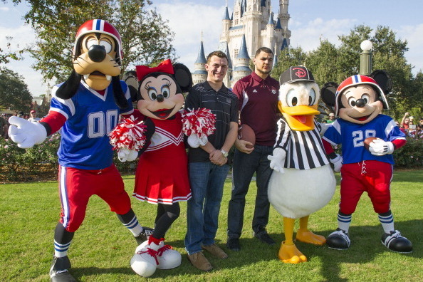 LAKE BUENA VISTA, FL - DECEMBER 11:  In this handout photo provided by Disney Parks, Texas A&M quarterback Johnny Manziel (L) and Texas A&M wide receiver Mike Evans (R) pose with Disney characters at the Magic Kingdom park at Walt Disney World Resort  Dec