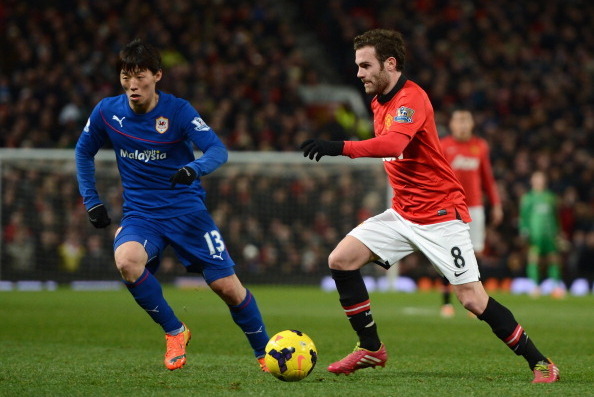 MANCHESTER, ENGLAND - JANUARY 28:  Juan Mata of Manchester United competes with Kim Bo-Kyung of Cardiff City during the Barclays Premier League match between Manchester United and Cardiff City at Old Trafford on January 28, 2014 in Manchester, England.  (