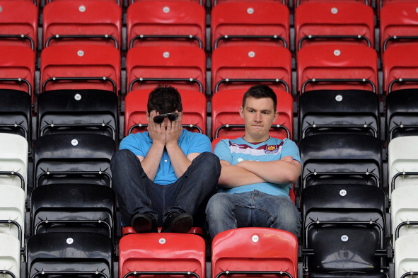 WIGAN, ENGLAND - MAY 15:  West Ham United fans look dejected following their relegation at the end of the Barclays Premier League match between Wigan Athletic and West Ham United at the DW Stadium on May 15, 2011 in Wigan, England.  (Photo by Chris Brunsk