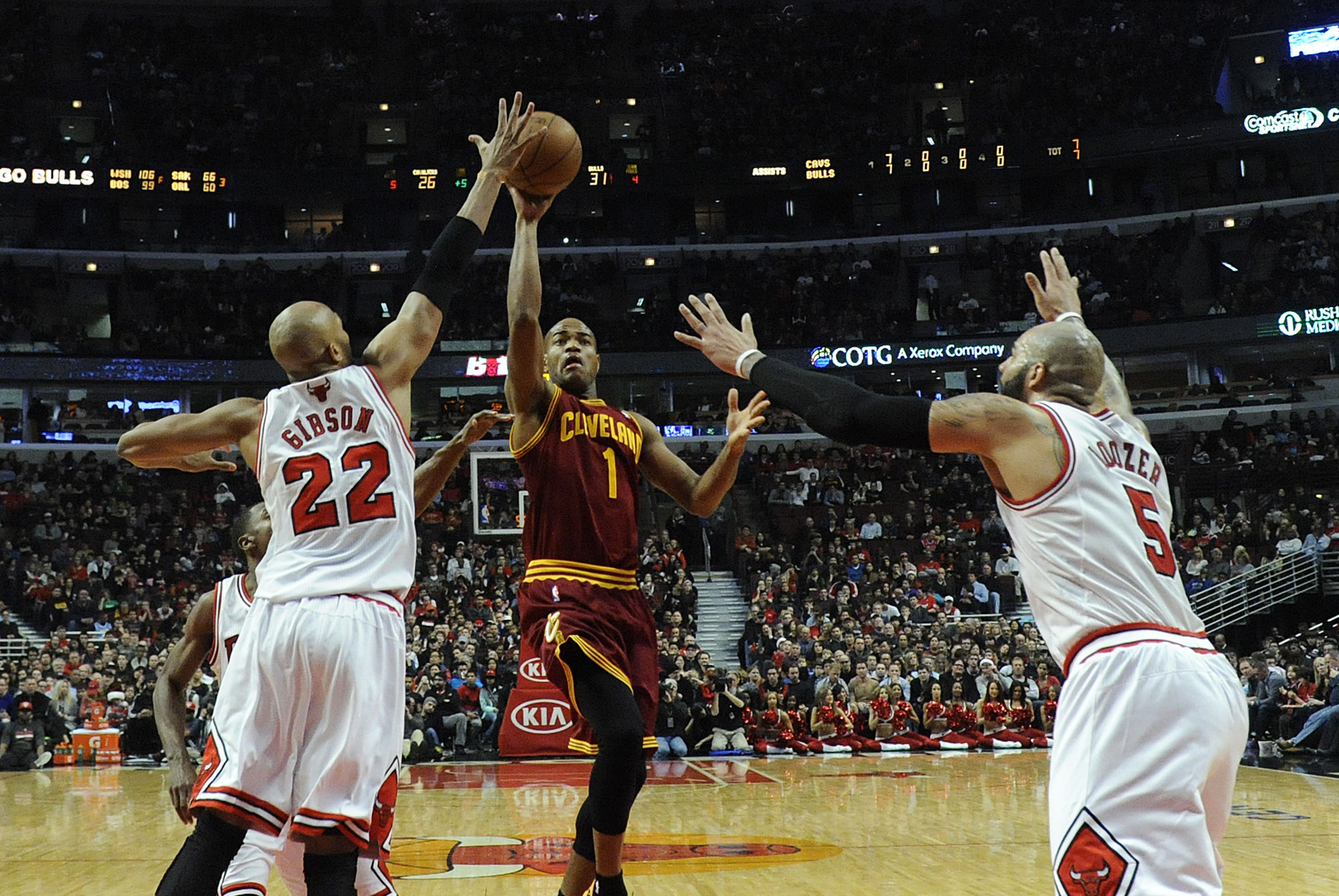 Dec 21, 2013; Chicago, IL, USA; Cleveland Cavaliers point guard Jarrett Jack (1) shoots over Chicago Bulls power forward Taj Gibson (22) and power forward Carlos Boozer (5) during the first quarter at the United Center. Mandatory Credit: David Banks-USA T