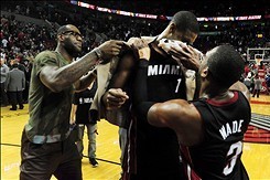 Dec 28, 2013; Portland, OR, USA; Miami Heat small forward LeBron James (left) and shooting guard Dwyane Wade (3) celebrate with center Chris Bosh (1) after Bosh hit the game winning shot in the game against the Portland Trail Blazers at the Moda Center. T
