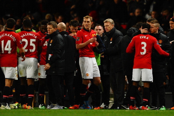 MANCHESTER, ENGLAND - JANUARY 22:  David Moyes the Manchester United manager speaks with his players prior to extra time during the Capital One Cup semi final, second leg match between Manchester United and Sunderland at Old Trafford on January 22, 2014 i