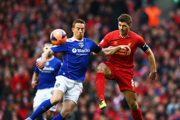LIVERPOOL, ENGLAND - JANUARY 05: Steven Gerrard of Liverpool challenges Adam Rooney of Oldham during the Budweiser FA Cup third round match between Liverpool and Oldham Athletic at Anfield on January 5, 2014 in Liverpool, England.  (Photo by Clive Mason/G