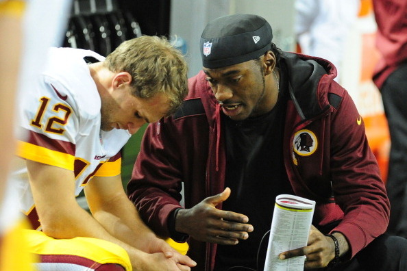 ATLANTA, GA - DECEMBER 15: Kirk Cousins #12 of the Washington Redskins chats with Robert Griffin III after throwing a 4th quarter interception against the Atlanta Falcons at the Georgia Dome on December 15, 2013 in Atlanta, Georgia. (Photo by Scott Cunnin