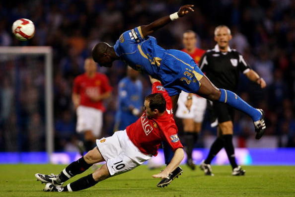 PORTSMOUTH, UNITED KINGDOM - AUGUST 25:  Wayne Rooney of Manchester United gets tackled by Sol Cambell of Portsmouth during the Barclays Premier League match between Portsmouth and Manchester United at Fratton Park on August 25, 2008 in Portsmouth, Englan