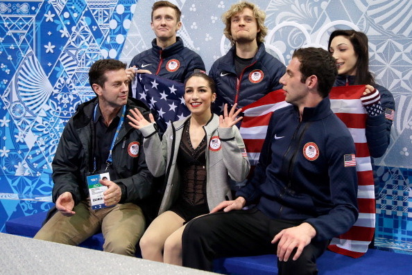 SOCHI, RUSSIA - FEBRUARY 06:  Marissa Castelli (front C) and Simon Shnapir (front R) of the United States wait for their scores with coach Robert Martin (front L) and teammates (back L-R) Jeremy Abbott, Charlie White and Meryl Davis in the Figure Skating 