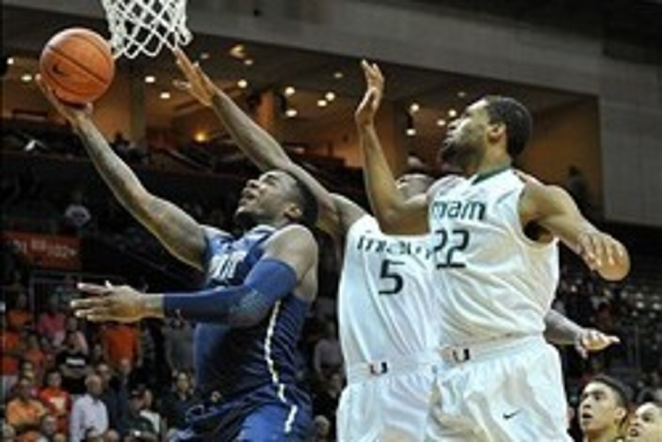 Feb 5, 2014; Coral Gables, FL, USA; Pittsburgh Panthers forward Michael Young (2) shoots the ball in front of Miami Hurricanes guard Davon Reed (5) and Miami Hurricanes forward Donnavan Kirk (22) during the first half at BankUnited Center. Mandatory Credi
