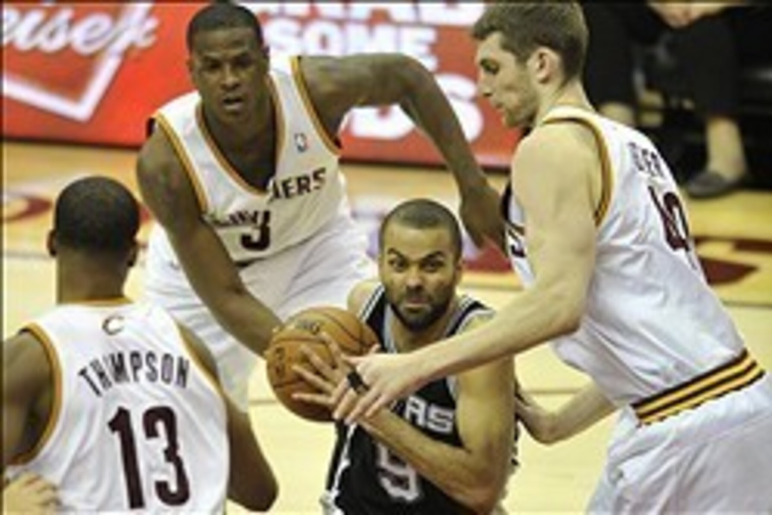 Feb 13, 2013; Cleveland, OH, USA; San Antonio Spurs point guard Tony Parker (9) drives between Cleveland Cavaliers power forward Tristan Thompson (13), shooting guard Dion Waiters (3) and center Tyler Zeller (40) in the fourth quarter at Quicken Loans Are