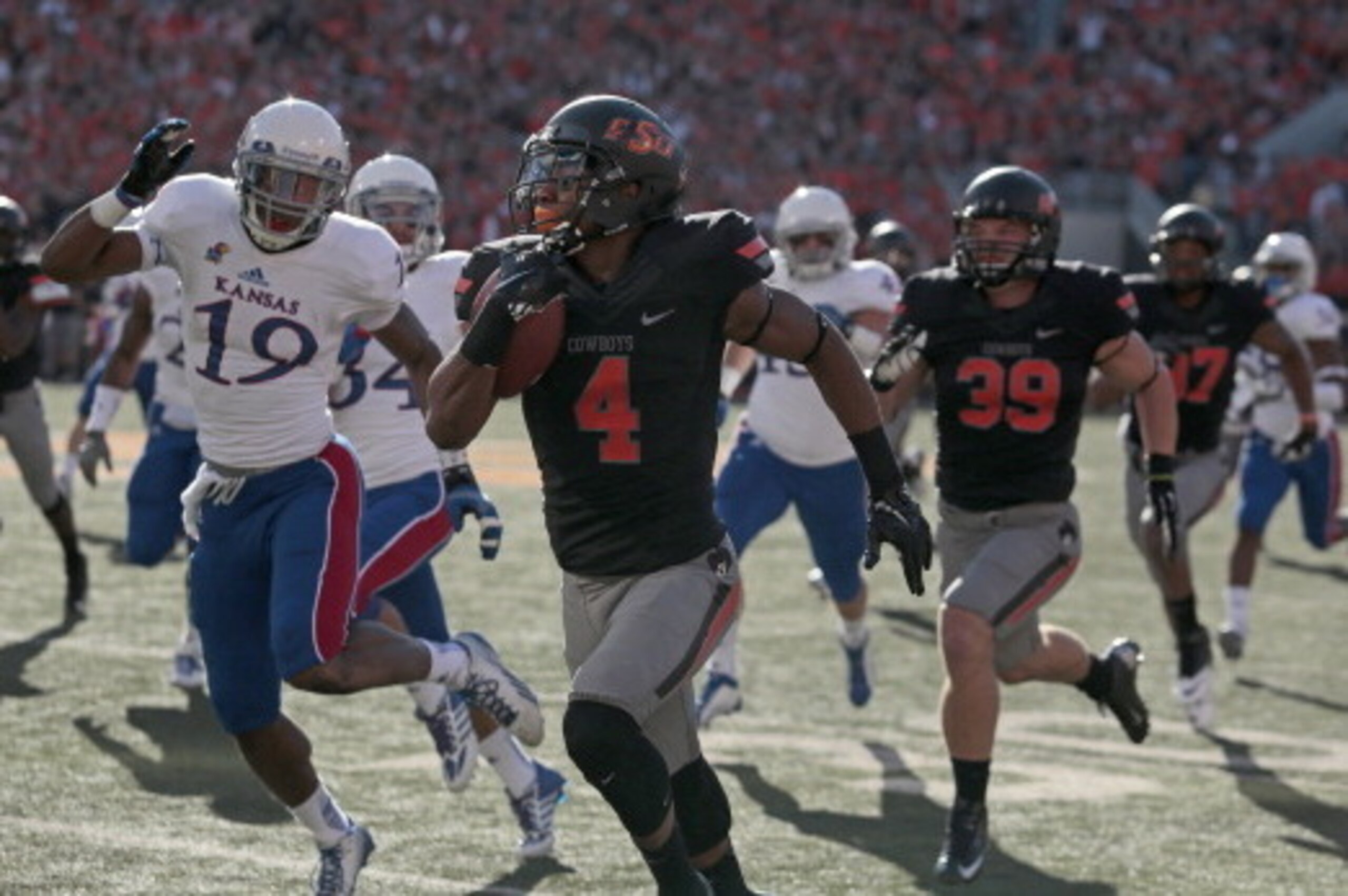 STILLWATER, OK - NOVEMBER 09:  Cornerback Justin Gilbert #4 of the Oklahoma State Cowboys runs downfield for a touchdown on the opening kickoff against the Kansas Jayhawks Novemeber 9, 2013 at Boone Pickens Stadium in Stillwater, Oklahoma. The Cowboys def