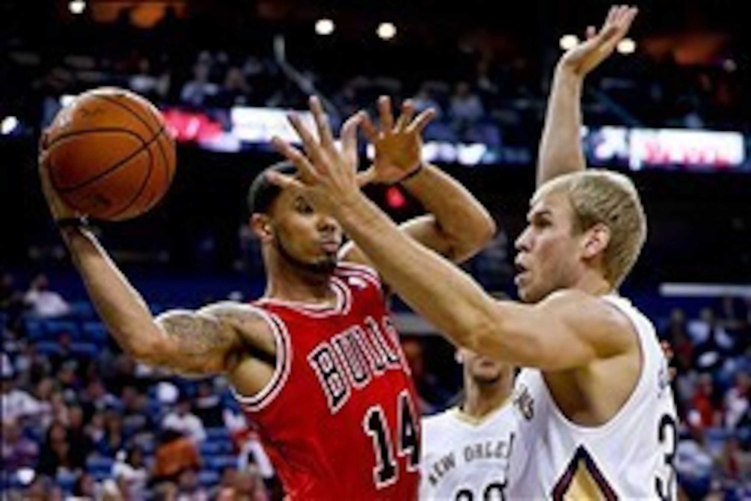 Feb 1, 2014; New Orleans, LA, USA; Chicago Bulls point guard D.J. Augustin (14) passes as New Orleans Pelicans center Greg Stiemsma (34) defends during the first quarter of a game at the New Orleans Arena. Mandatory Credit: Derick E. Hingle-USA TODAY Spor