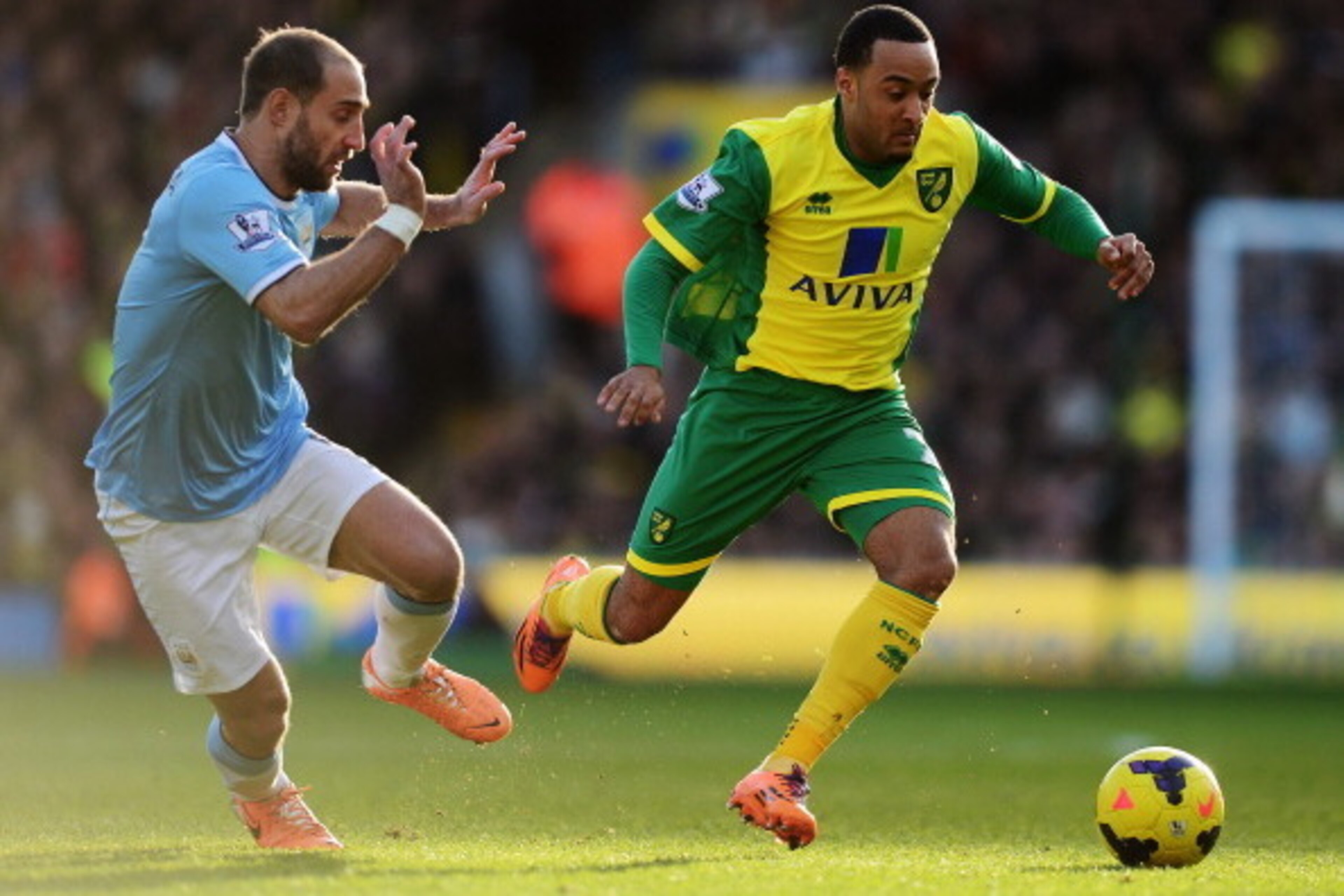 NORWICH, ENGLAND - FEBRUARY 08:  Nathan Redmond (R) of Norwich City holds off the challenge of Pablo Zabaleta (L) of Manchester City during the Barclays Premier League match between Norwich City and Manchester City at Carrow Road on February 8, 2014 in No