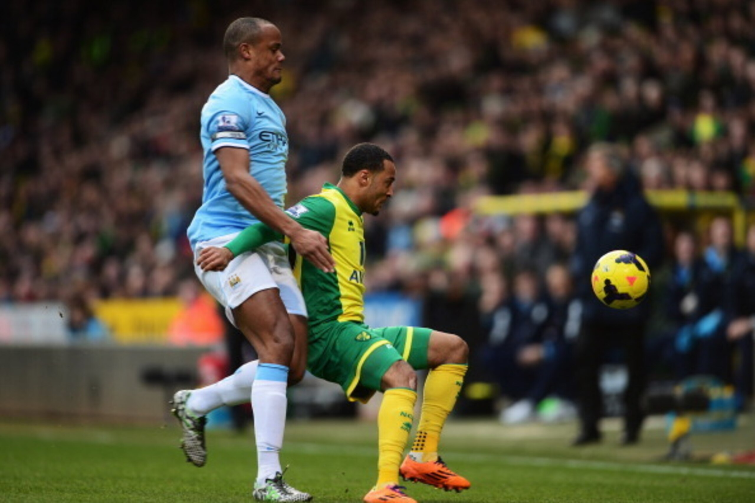 NORWICH, ENGLAND - FEBRUARY 08: Nathan Redmond (R) of Norwich City holds off the challenge of Vincent Kompany (L) of Manchester City during the Barclays Premier League match between Norwich City and Manchester City at Carrow Road on February 8, 2014 in N NORWICH, ENGLAND - FEBRUARY 08: Nathan Redmond (R) of Norwich City holds off the challenge of Vincent Kompany (L) of Manchester City during the Barclays Premier League match between Norwich City and Manchester City at Carrow Road on February 8, 2014 in N