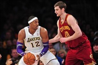 January 13, 2013; Los Angeles, CA, USA; Los Angeles Lakers center Dwight Howard (12) controls the ball against the defense of Cleveland Cavaliers center Tyler Zeller (40) during the first half at Staples Center. Mandatory Credit: Gary A. Vasquez-USA TODAY