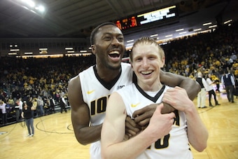 IOWA CITY, IA - FEBRUARY 08:  Center Gabriel Olaseni #0 celebrates with guard Mike Gesell #10 of the Iowa Hawkeyes after defeating the Michigan Wolverines on February 8, 2014 at Carver-Hawkeye Arena, in Iowa City, Iowa. Iowa won 85-67. (Photo by Matthew H