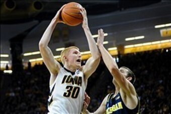 Feb 8, 2014; Iowa City, IA, USA; Iowa Hawkeyes guard-forward Aaron White (30) attempts a shot over Michigan Wolverine guard Nik Stauskas (11) at Carver-Hawkeye Arena. Iowa defeated Michigan 85-67. Mandatory Credit: Steven Branscombe-USA TODAY Sports