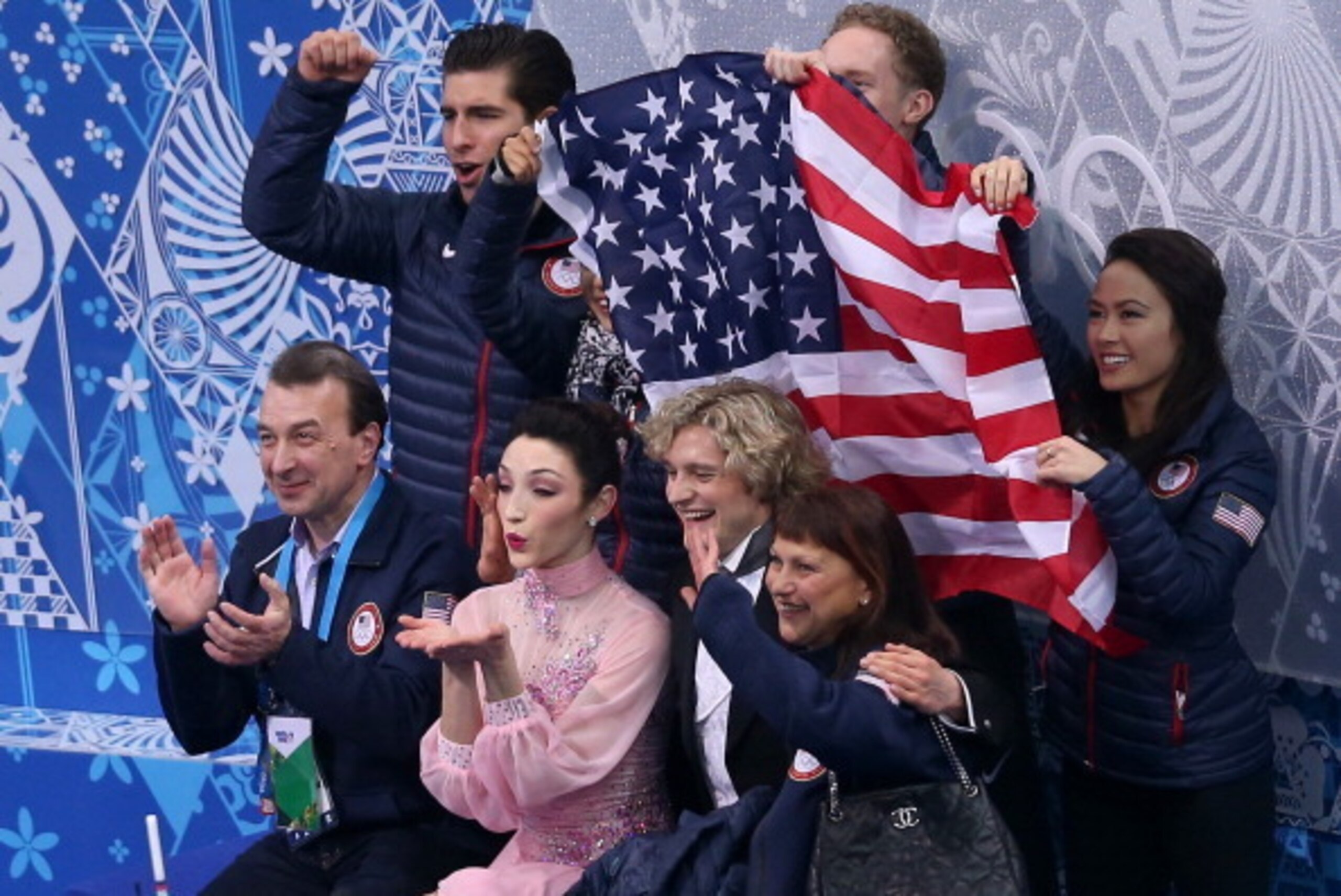 SOCHI, RUSSIA - FEBRUARY 08:  Meryl Davis and Charlie White of the United States wait for their score with teammates and coaches during the Figure Skating Team Ice Dance - Short Dance during day one of the Sochi 2014 Winter Olympics at Iceberg Skating Pal