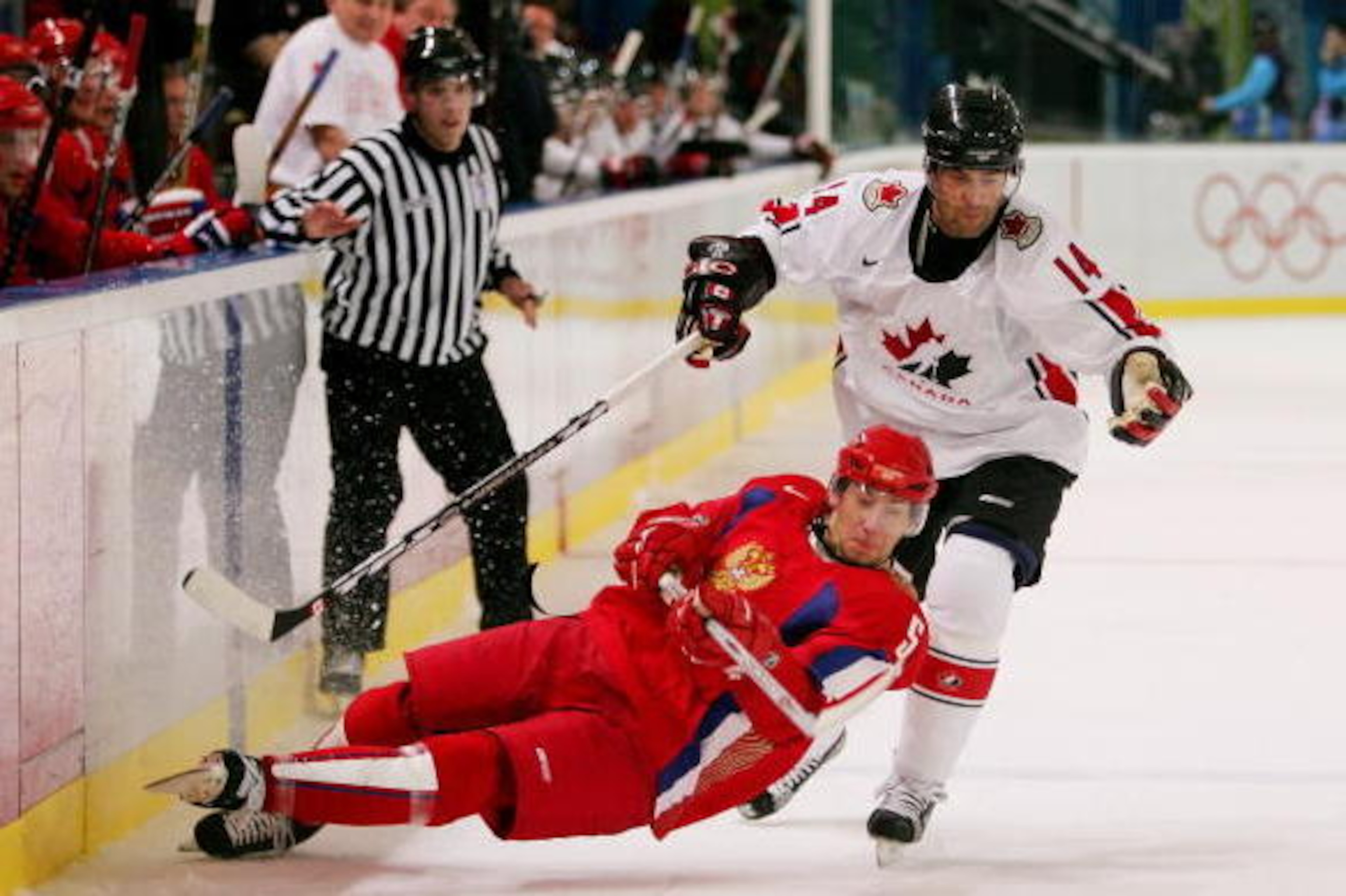 TURIN, ITALY - FEBRUARY 22: Vitali Vishnevski #5 of Russia falls down trying to keep the puck from Todd Bertuzzi #14 of Canada during the quarter final of the men's ice hockey match during Day 12 of the Turin 2006 Winter Olympic Games on February 22, 200 TURIN, ITALY - FEBRUARY 22: Vitali Vishnevski #5 of Russia falls down trying to keep the puck from Todd Bertuzzi #14 of Canada during the quarter final of the men's ice hockey match during Day 12 of the Turin 2006 Winter Olympic Games on February 22, 200