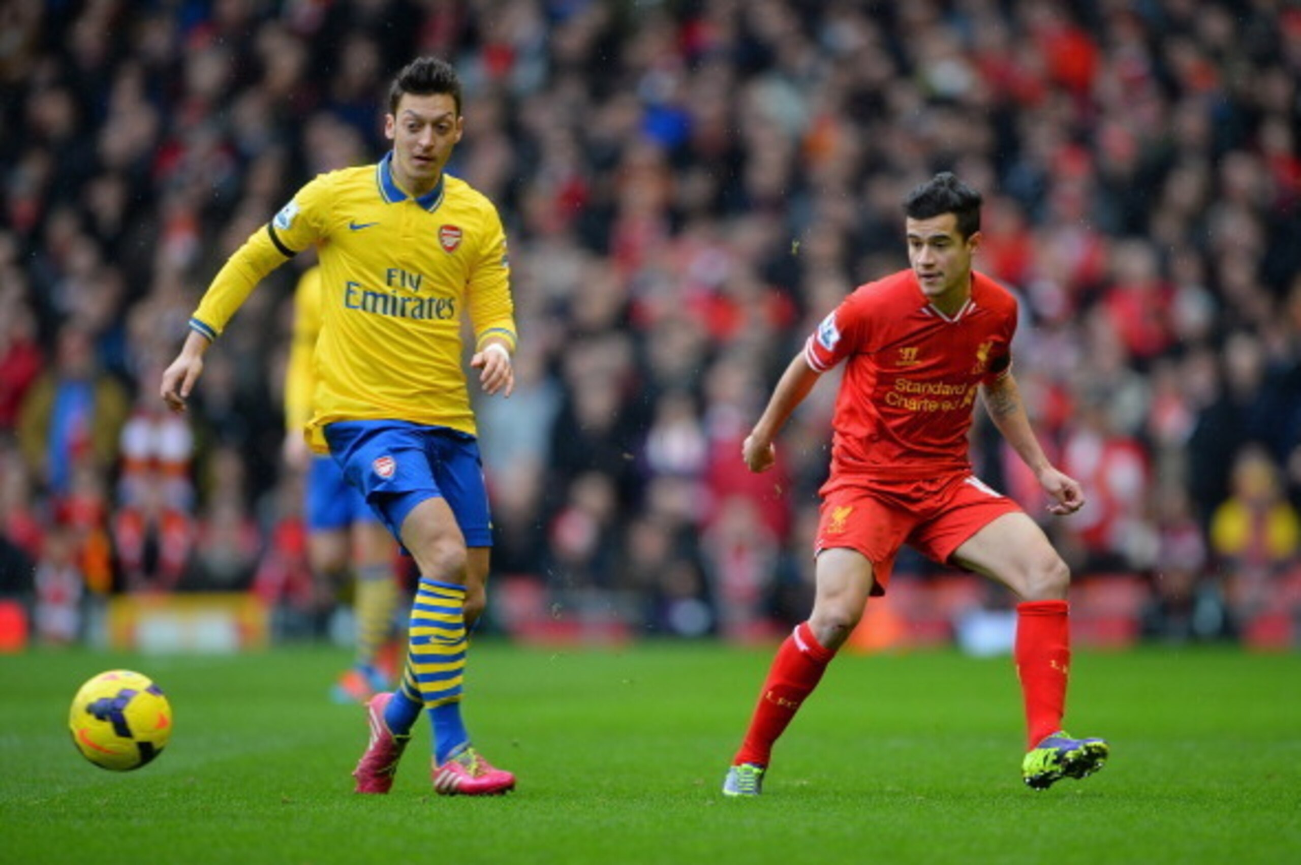 LIVERPOOL, ENGLAND - FEBRUARY 08:  Coutinho of Liverpool competes with Mesut Ozil of Arsenal during the Barclays Premier League match between Liverpool and Arsenal at Anfield on February 8, 2014 in Liverpool, England.  (Photo by Michael Regan/Getty Images