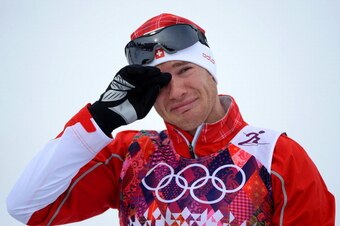 SOCHI, RUSSIA - FEBRUARY 09:  Gold medalist Dario Cologna of Switzerland reacts on the podium during the flower ceremony for the Men's Skiathlon 15 km Classic + 15 km Free during day two of the Sochi 2014 Winter Olympics at Laura Cross-country Ski & Biath