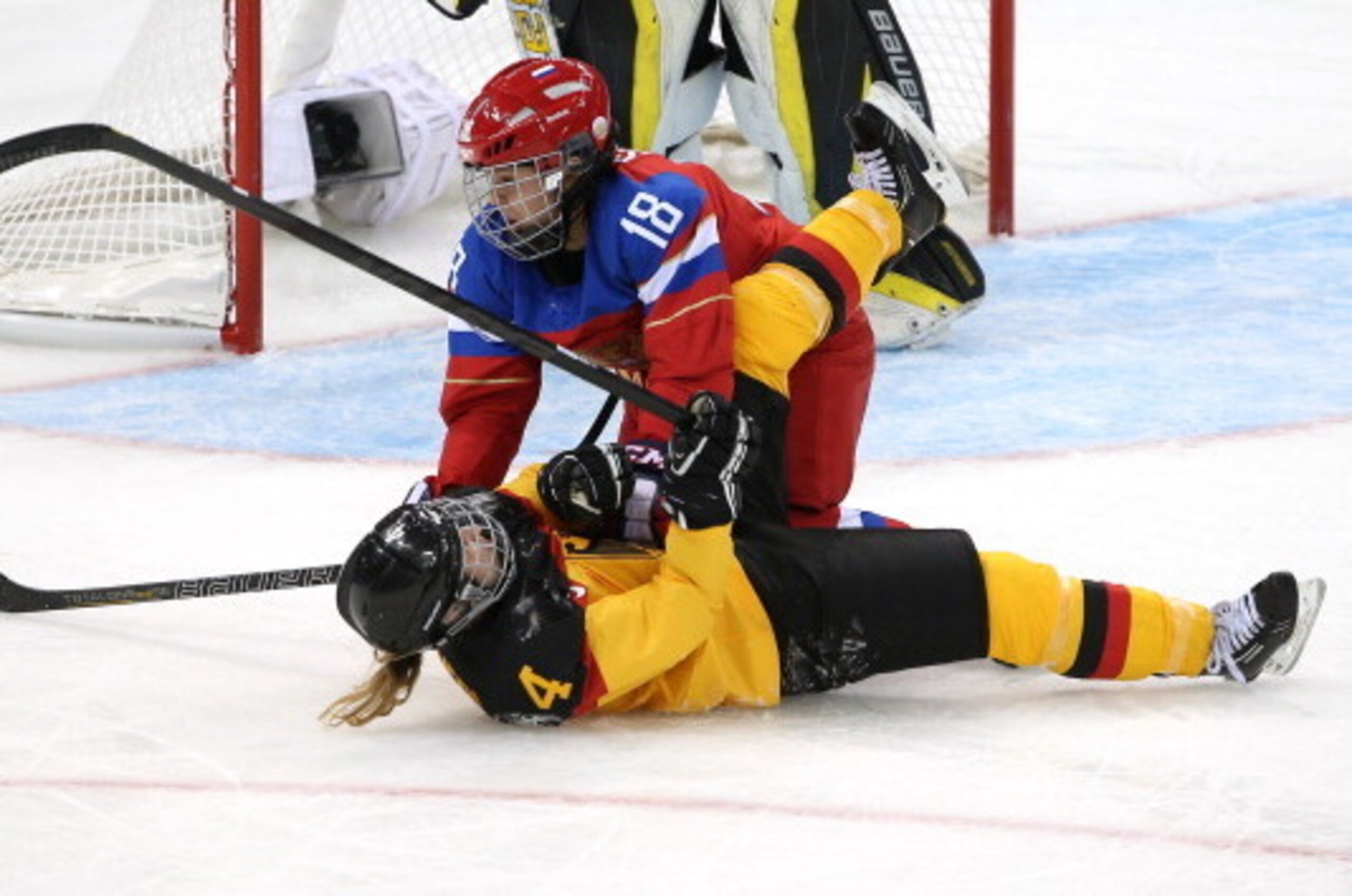 SOCHI, RUSSIA - FEBRUARY 09:  Jessica Hammerl #4 of Germany and Olga Sosina #18 of Russia collide during the Women's Ice Hockey Preliminary Round Group B Game on day two of the Sochi 2014 Winter Olympics at Shayba Arena on February 9, 2014 in Sochi, Russi