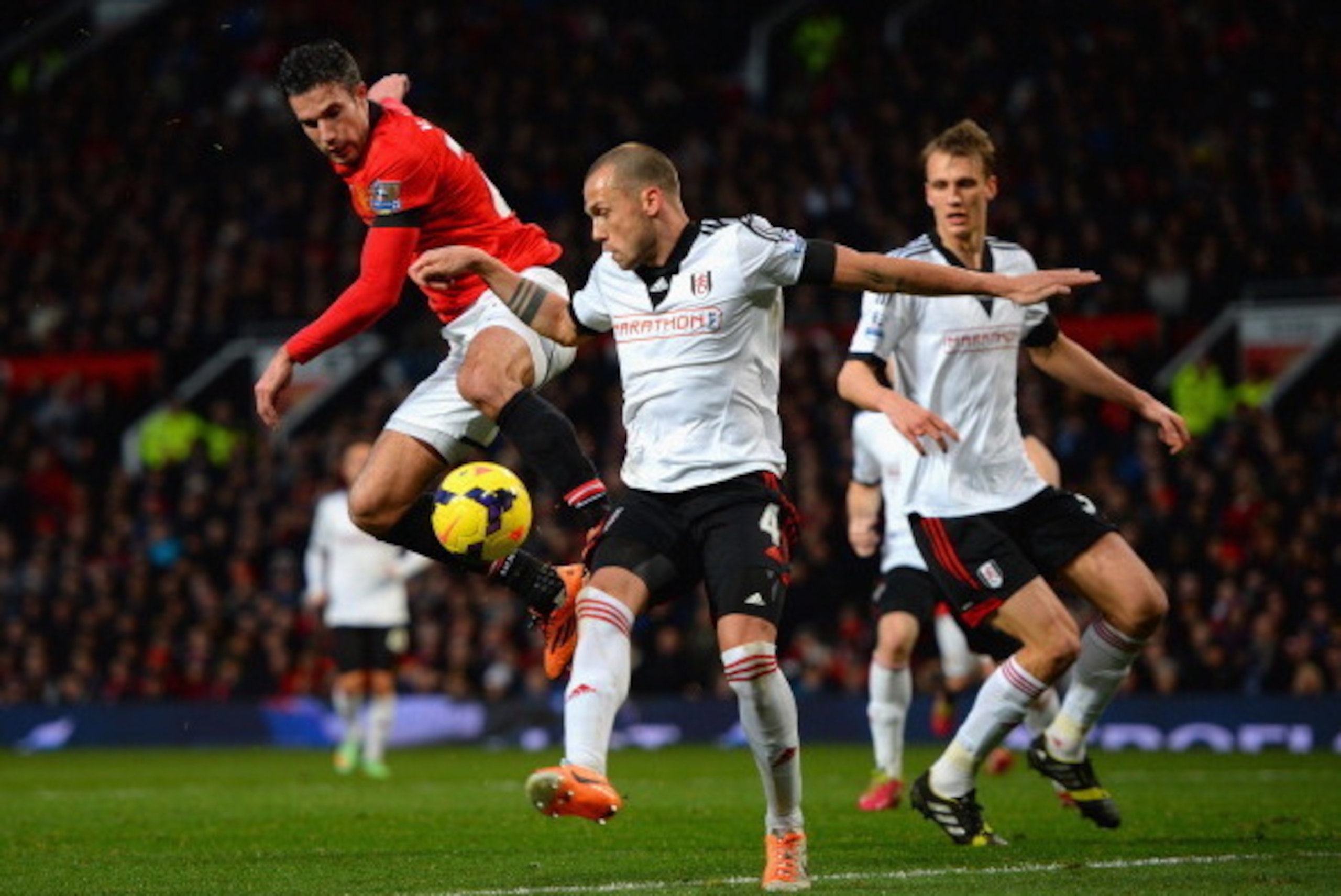 MANCHESTER, ENGLAND - FEBRUARY 09:   Robin van Persie of Manchester United competes with John Heitinga of Fulham during the Barclays Premier League match between Manchester United and Fulham at Old Trafford on February 9, 2014 in Manchester, England.  (Ph