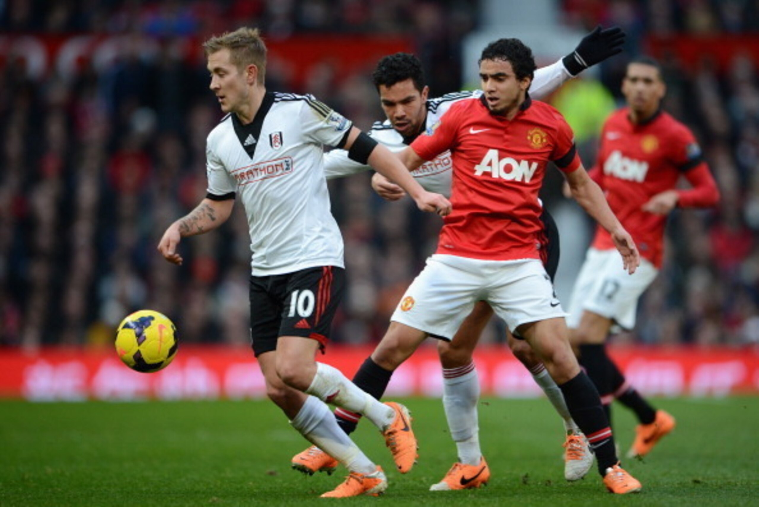 MANCHESTER, ENGLAND - FEBRUARY 09:  Rafael of Manchester United competes with Lewis Holtby (L) and Kieran Richardson of Fulham during the Barclays Premier League match between Manchester United and Fulham at Old Trafford on February 9, 2014 in Manchester,