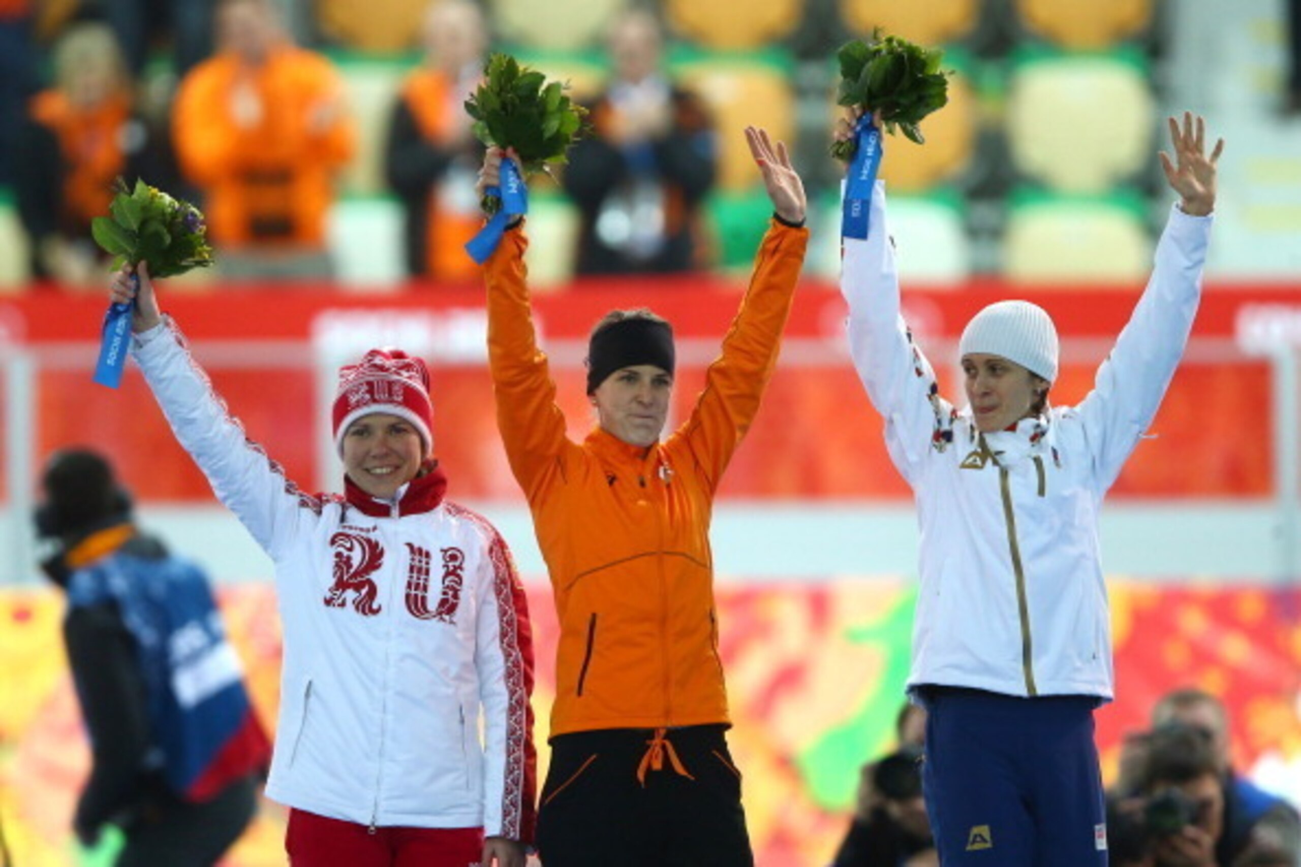 SOCHI, RUSSIA - FEBRUARY 09:  Silver medalist Martina Sablikova of the Czech Republic (R), gold medalist Irene Wust of the Netherlands (C) and bronze medalist Olga Graf of Russia celebrate on the podium during the flower ceremony for the Women's 3000m Spe