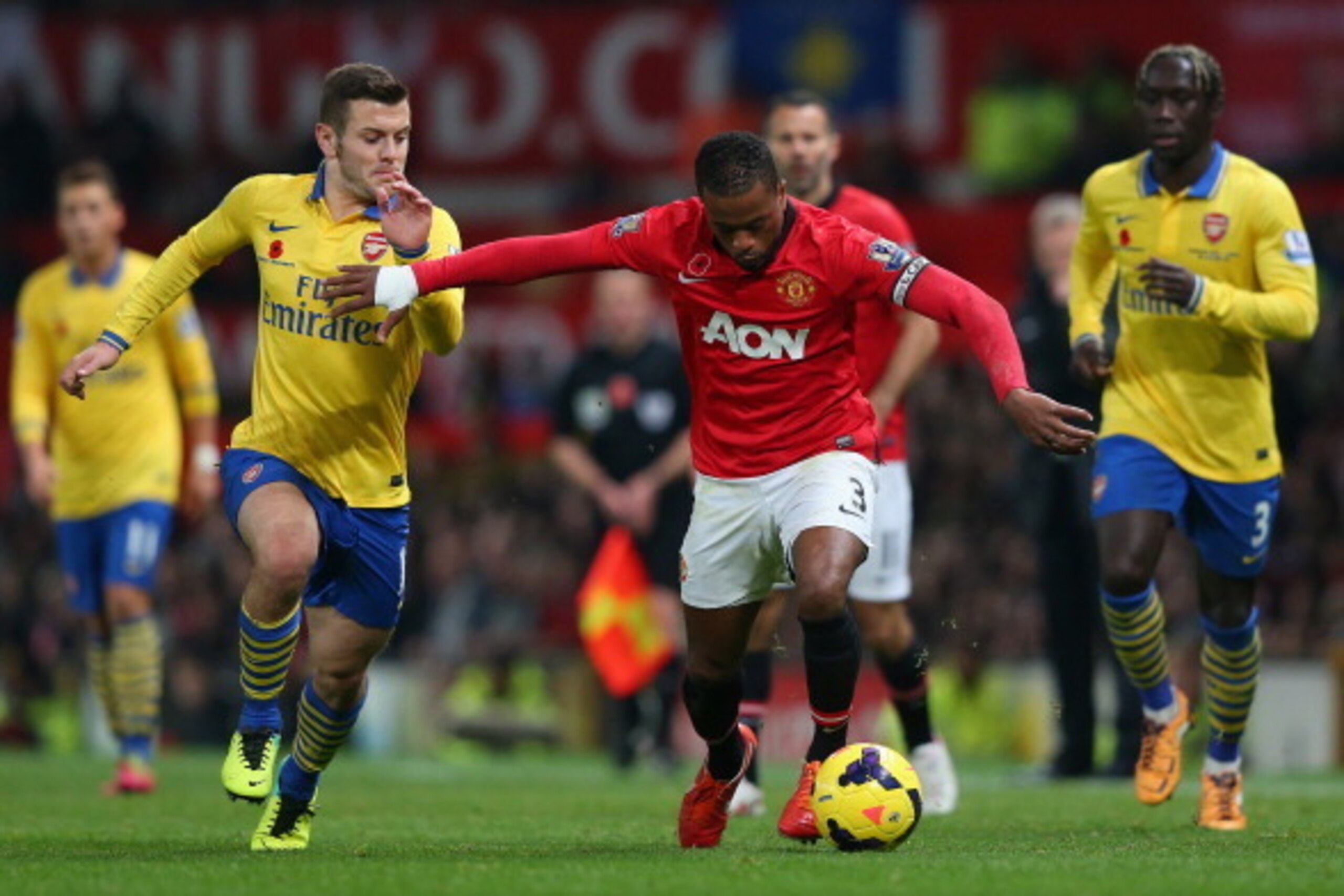 MANCHESTER, ENGLAND - NOVEMBER 10:  Patrice Evra of Manchester United battle for the ball with Jack Wilshere of Arsenal during the Barclays Premier League match between Manchester United and Arsenal at Old Trafford on November 10, 2013 in Manchester, Engl