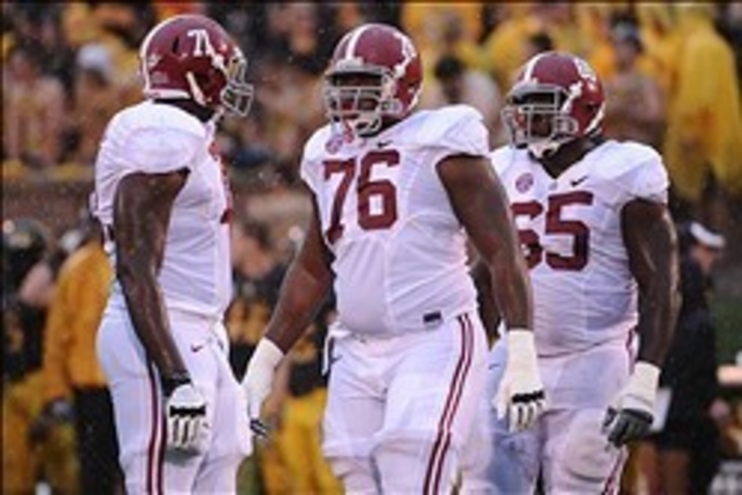 October 13, 2012; Columbia, MO, USA; Alabama Crimson Tide offensive linesman Cyrus Kouandjio (71) and offensive linesman D.J. Fluker (76) and offensive linesman Chance Warmack (65) talk during the first half at Faurot Field. Alabama won 42-10. Mandatory C