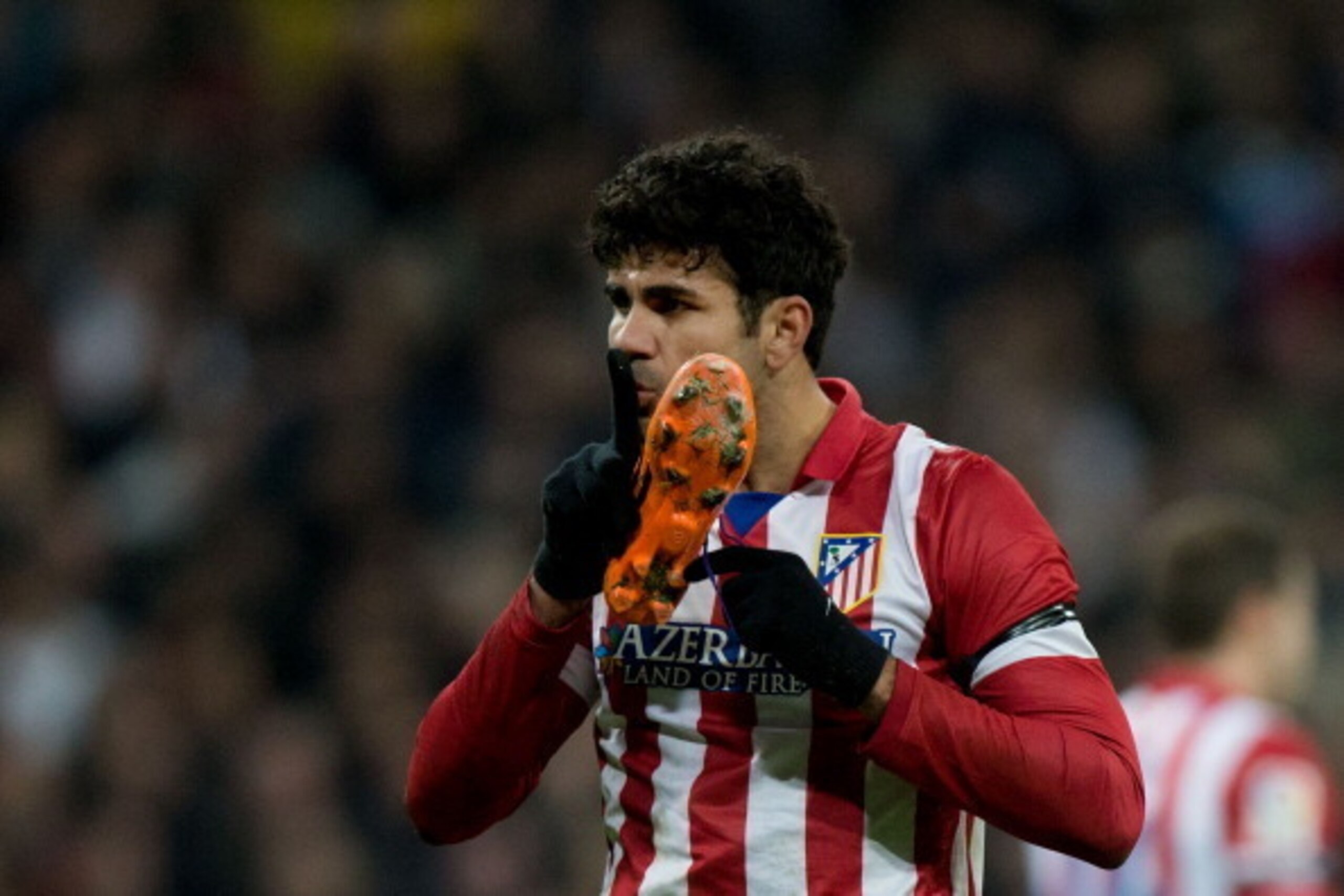 MADRID, SPAIN - FEBRUARY 05: Diego Costa of Atletico de Madrid presses his finger to his lips towards some Real Madrid players as he holds his shoe during the Copa del Rey semifinal first leg match between Real Madrid CF and Club Atletico Madrid at Estadi