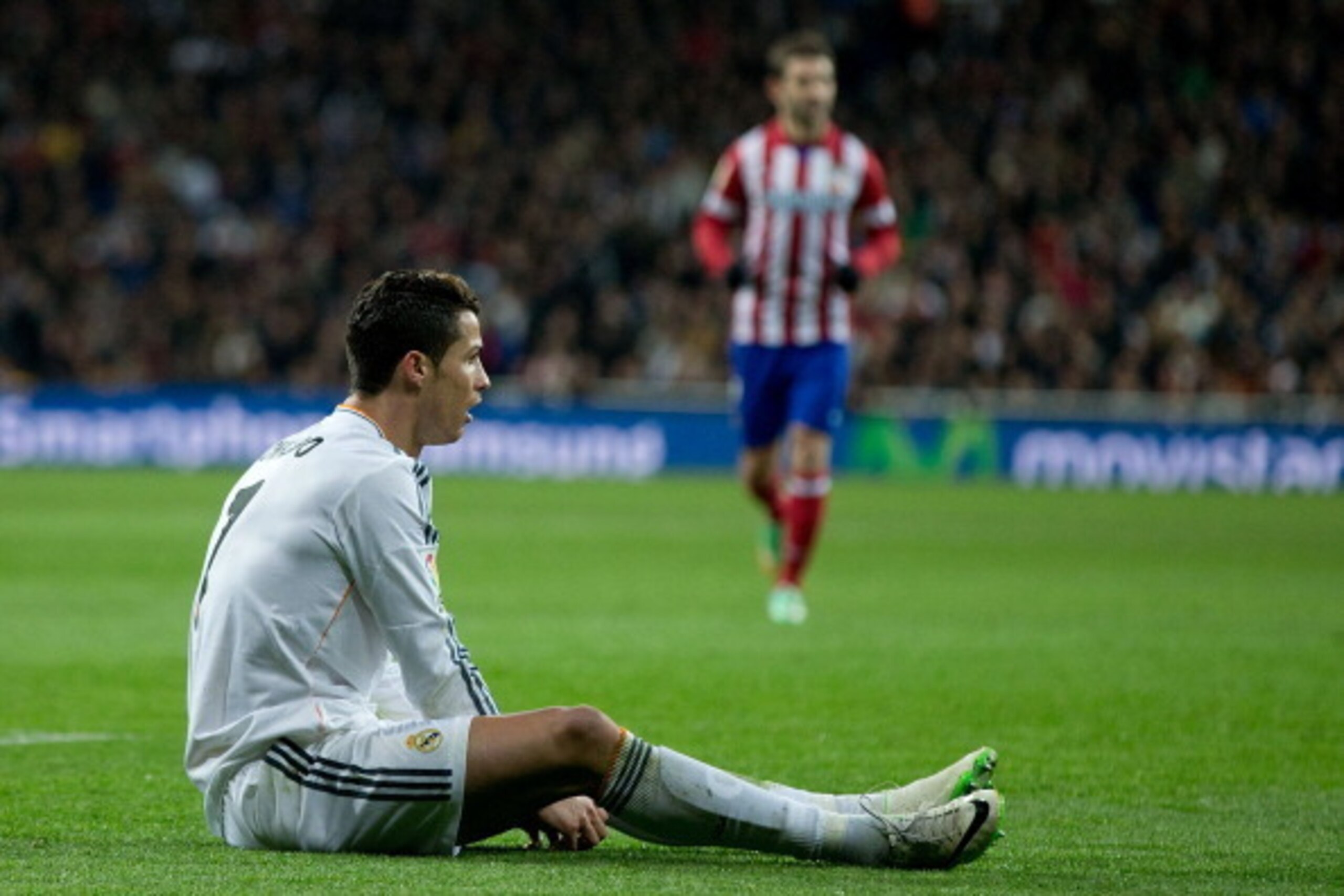 MADRID, SPAIN - FEBRUARY 05: Cristiano Ronaldo of Real Madrid CF lies on the ground after being tackled during the Copa del Rey semifinal first leg match between Real Madrid CF and Club Atletico Madrid at Estadio Santiago Bernabeu on February 5, 2014 in M