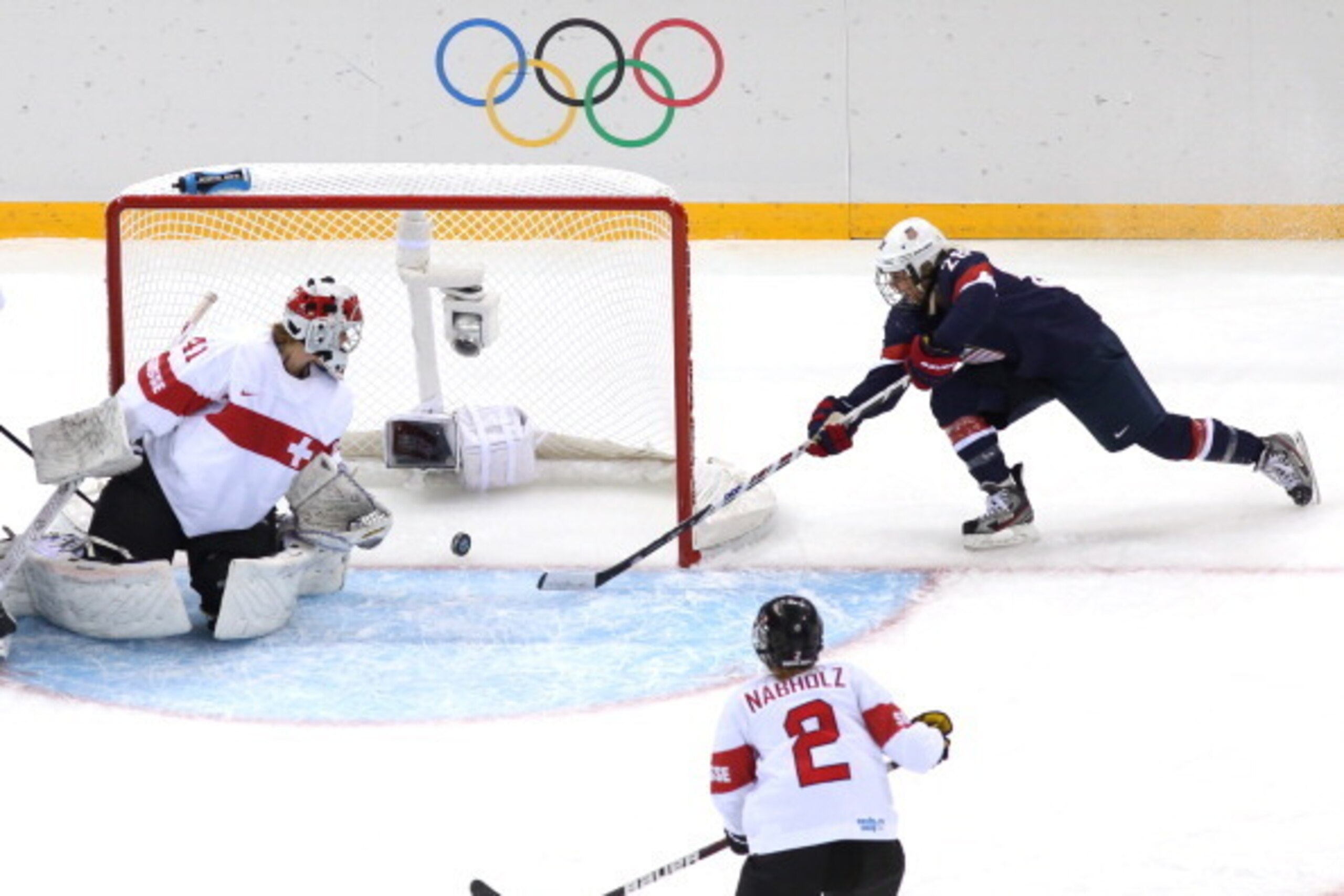 SOCHI, RUSSIA - FEBRUARY 10:  Amanda Kessel #28 of United States stretches for the puck on the goal line next to Florence Schelling #41 of Switzerland during the Women's Ice Hockey Preliminary Round Group A game on day three of the Sochi 2014 Winter Olymp