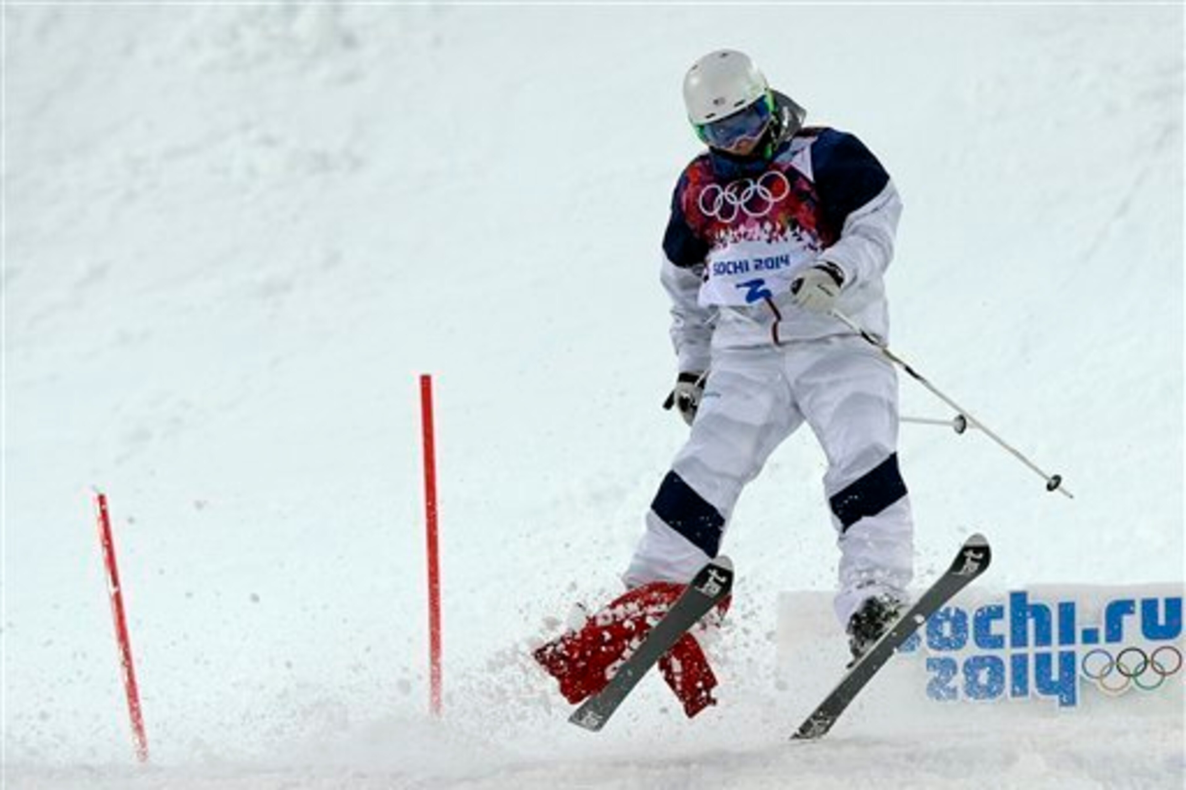 Patrick Deneen drags a flag with him during his run in moguls.