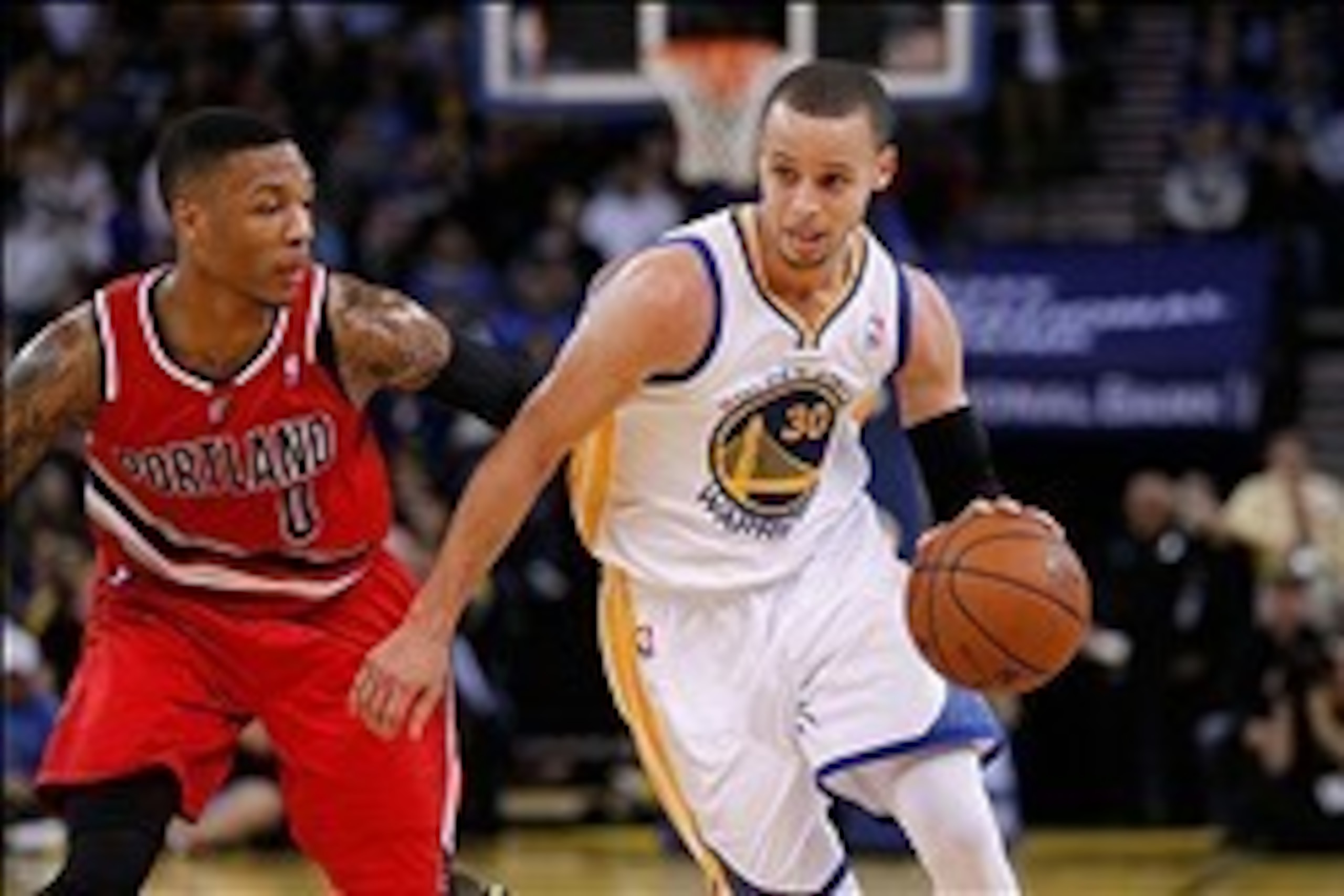Jan 26, 2014; Oakland, CA, USA; Golden State Warriors guard Stephen Curry (30) drives past Portland Trail Blazers guard Damian Lillard (0) in the third quarter at Oracle Arena. The Warriors defeated the Trail Blazers 103-88. Mandatory Credit: Cary Edmonds