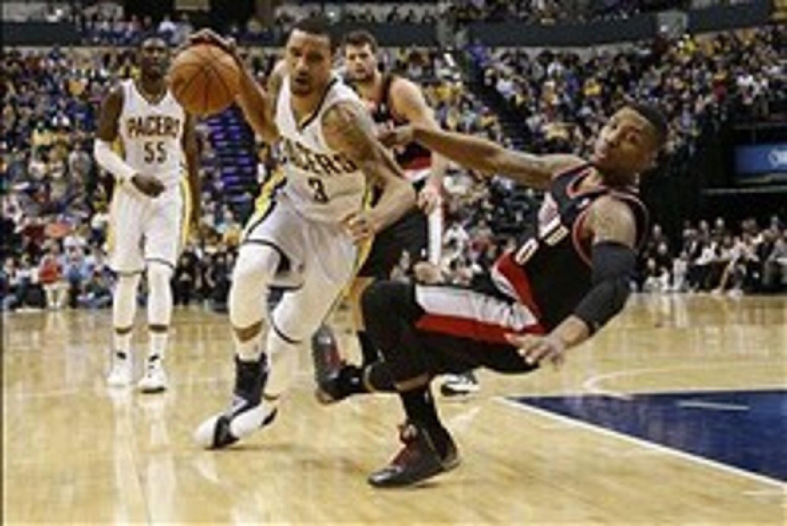 Feb 7, 2014; Indianapolis, IN, USA; Indiana Pacers guard George Hill (3) drives to the basket as Portland Trail Blazers guard Damian Lillard (0) is called for a blocking foul at Bankers Life Fieldhouse. Indiana defeats Portland 118-113 in overtime. Mandat