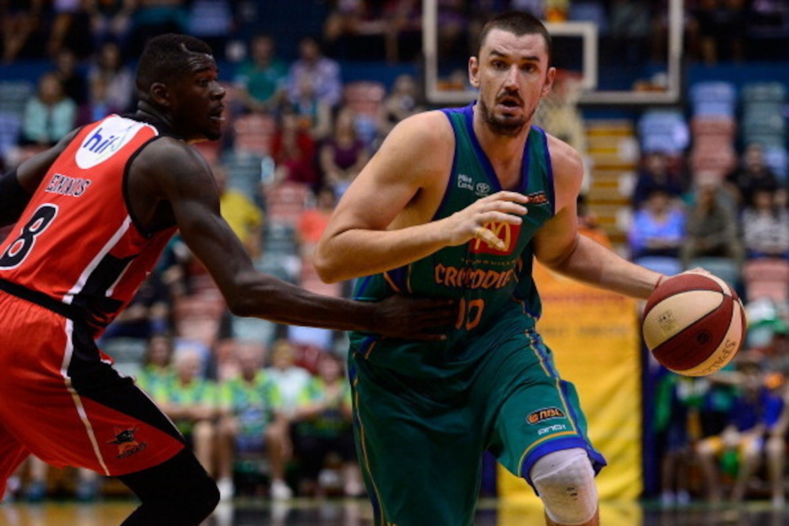 TOWNSVILLE, AUSTRALIA - FEBRUARY 07:  Russell Hinder of the Crocodiles drives past James Ennis of the Wildcats  during the round 17 NBL match between the Townsville Crocodiles and the Perth Wildcats at Townsville Entertainment Centre in February 7, 2014 i