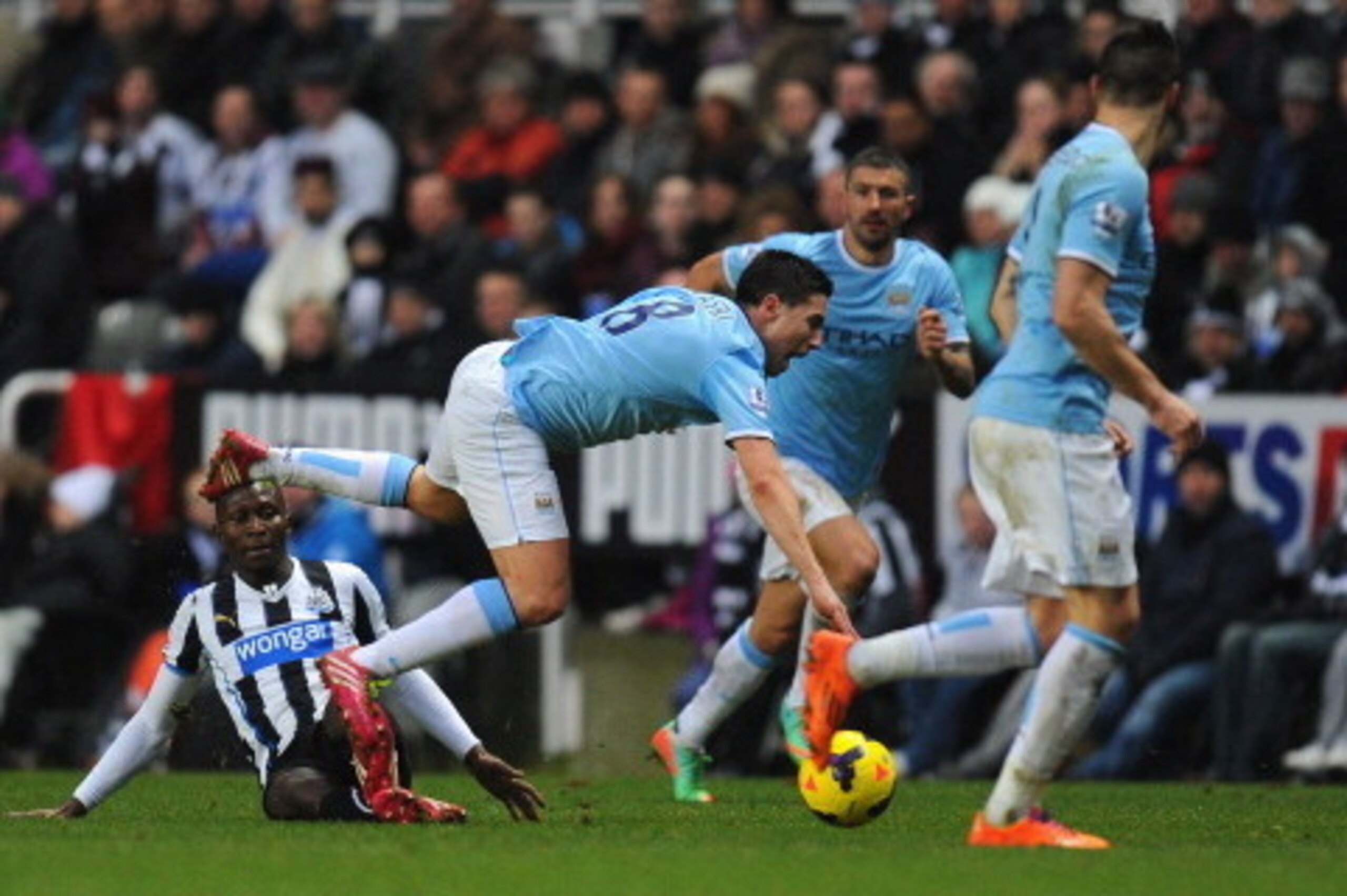 NEWCASTLE UPON TYNE, ENGLAND - JANUARY 12:  Newcastle player Mapou Yanga-Mbiwa (l) fouls Samir Nasri who is later stretchered off during the Barclays Premier League match between Newcastle United and Manchester City at St James' Park on January 12, 2014 i