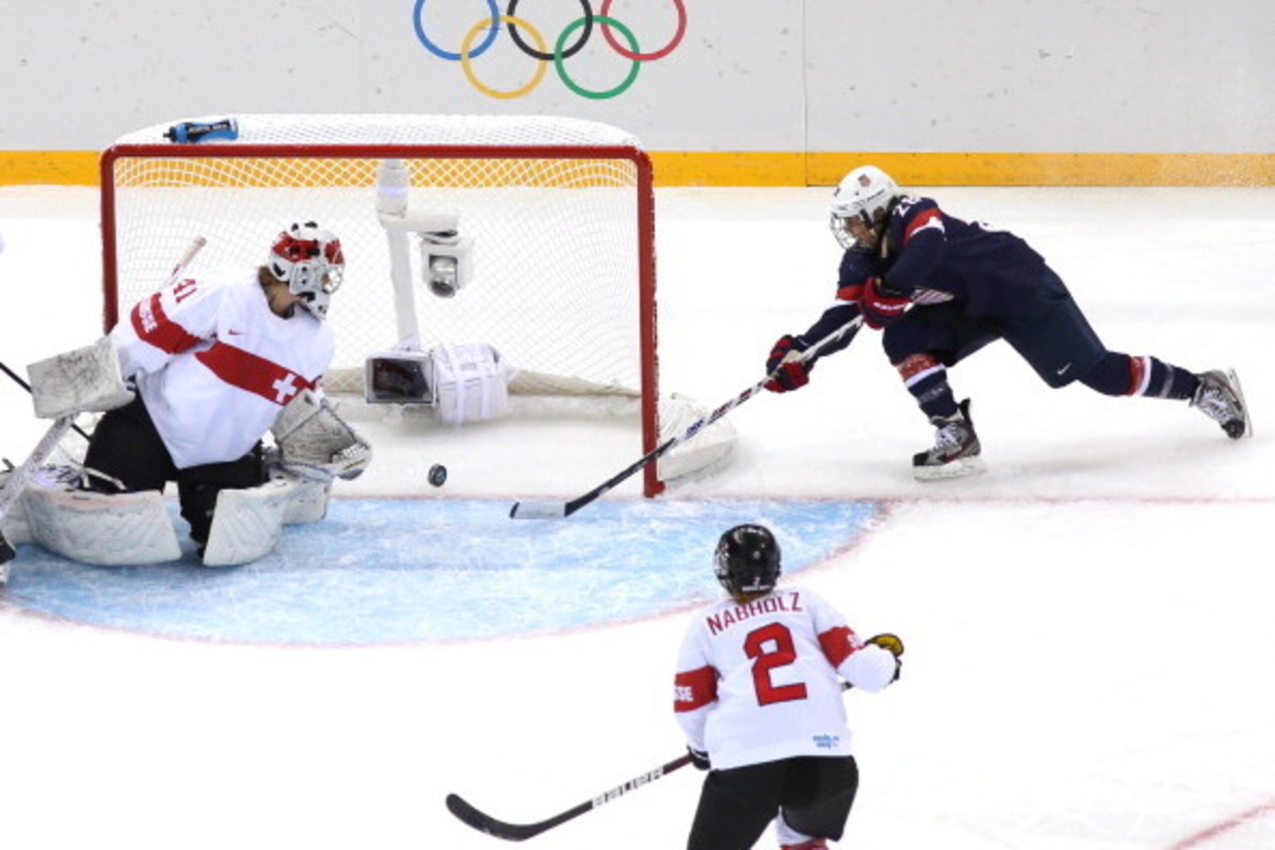 SOCHI, RUSSIA - FEBRUARY 10:  Amanda Kessel #28 of United States stretches for the puck on the goal line next to Florence Schelling #41 of Switzerland during the Women's Ice Hockey Preliminary Round Group A game on day three of the Sochi 2014 Winter Olymp