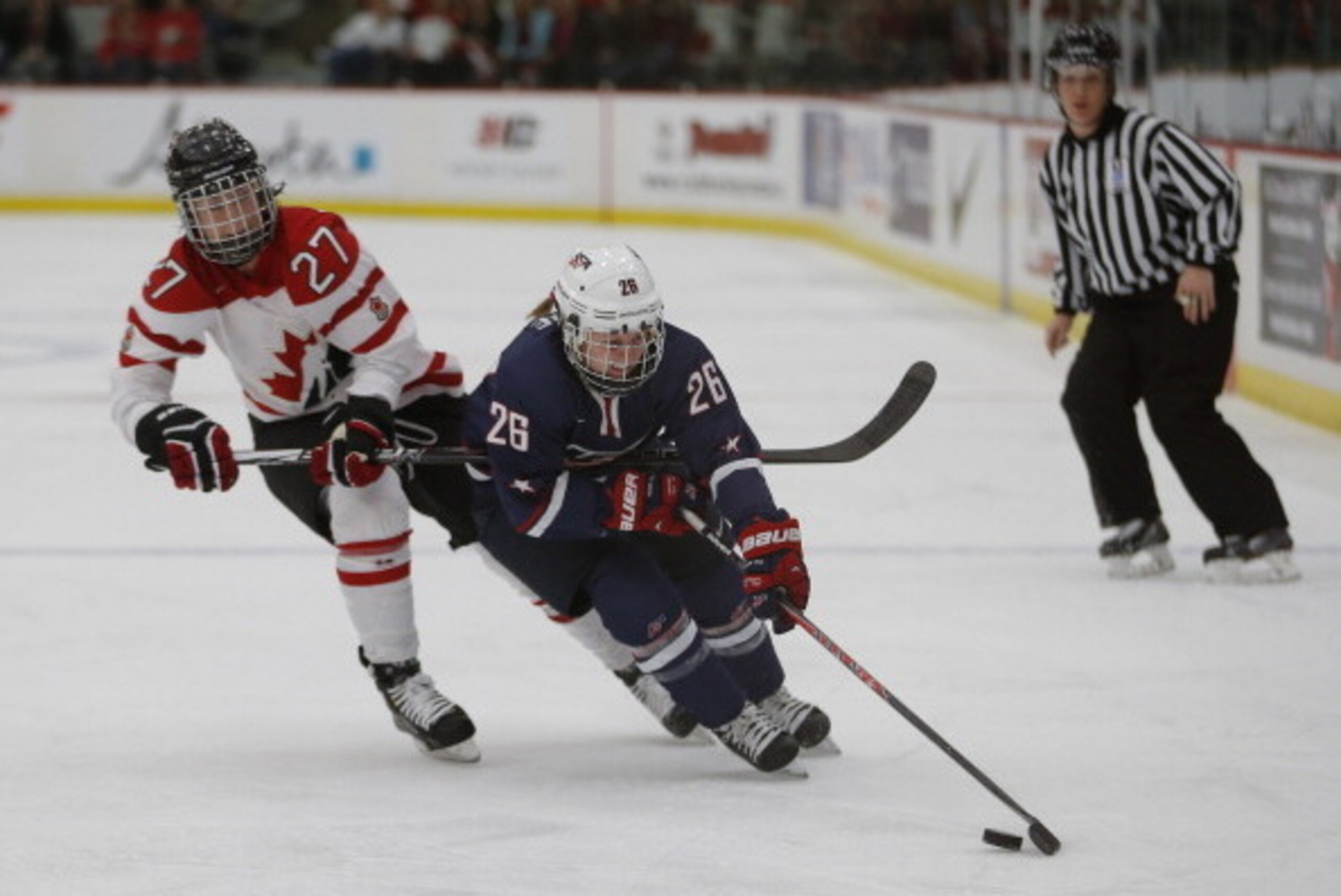 CALGARY, CANADA - DECEMBER 12: Team Canada's Tara Watchorn #27 tries to stop Team USA's Kendall Coyne #26 during the second period of their National Women's Team Series December 12, 2013 in Calgary, Alberta, Canada. (Photo by Todd Korol/Getty Images)