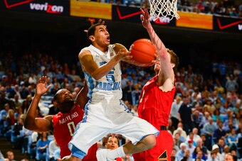 Feb 4, 2014; Chapel Hill, NC, USA; North Carolina Tar Heels guard Marcus Paige (5) scores as Maryland Terrapins forward Charles Mitchell (0) and forward Evan Smotrycz (1) defend in the second half. The North Carolina Tar Heels defeated the Maryland Terrap